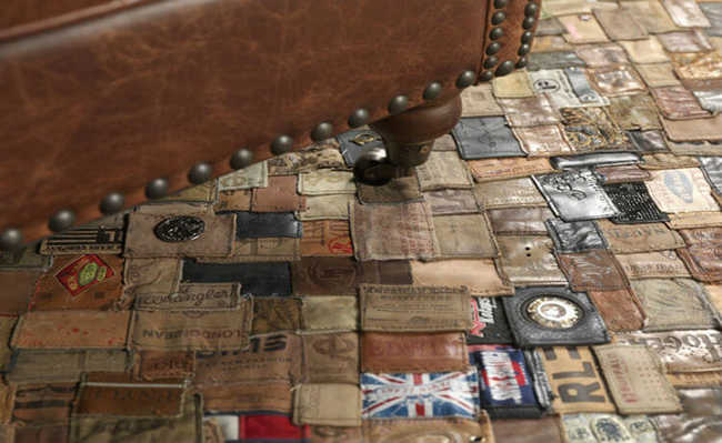Na imagem há um móvel sob um tapete de couro feito com etiquetas de couro encontradas em calças de denim  ou jeans.